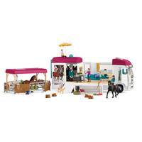 Spielzeugpferd-Anhänger-Set mit angebautem Wohnwagen, Reiter auf schwarzem Pferd, überdachter Stallbereich und Miniaturfiguren sowie Zubehör auf weißem Hintergrund.