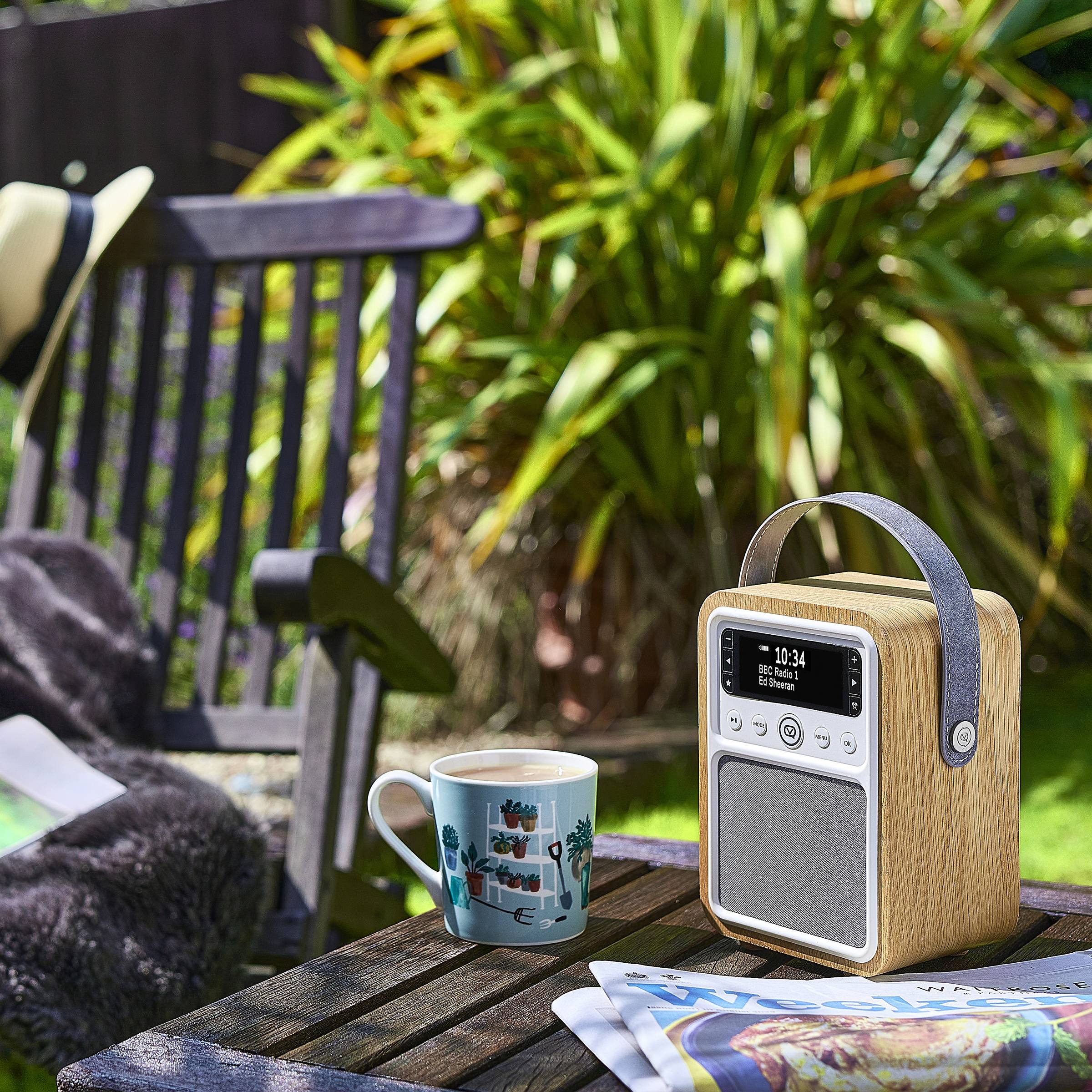Eine gemütliche Außenumgebung mit einem Holzradio, das „10:34 Fr 5. Mai