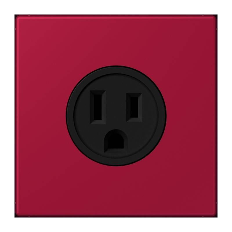 Eine rote elektrische Wandsteckdose mit einer schwarzen Buchse, die zwei vertikale Schlitze und ein rundes Loch darunter aufweist, was einem Gesicht ähnelt.