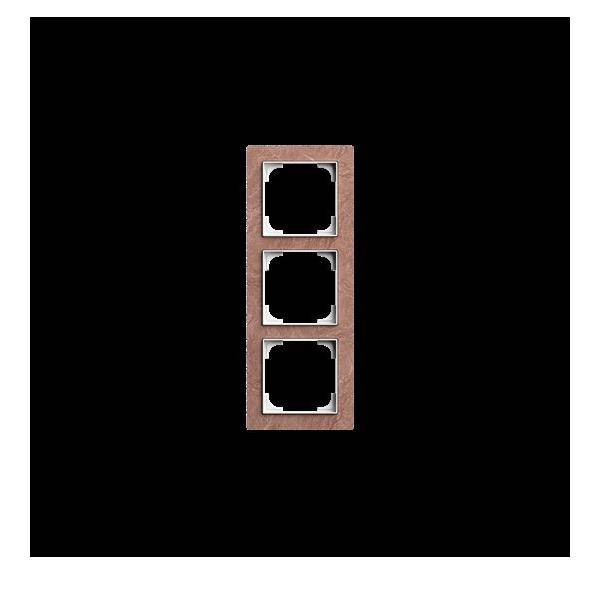 Eine Dreifach-Wandsteckdose mit leeren quadratischen Öffnungen, vor einem schwarzen Hintergrund. Der Rahmen hat eine Holzoptik.