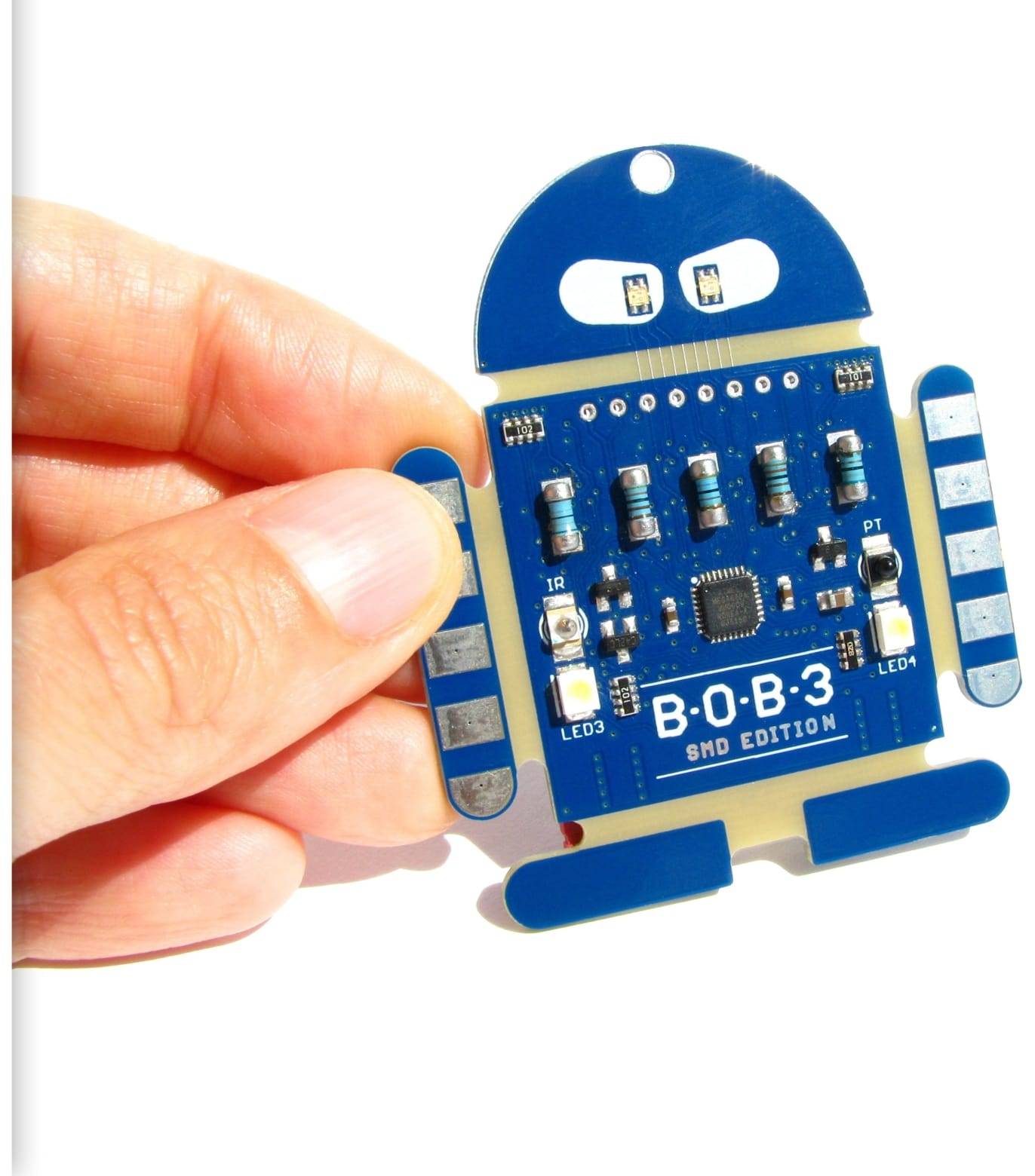 Eine Hand hält eine B-O-B 3 SMD Edition roboterförmige Leiterplatte mit mehreren blauen Komponenten und beschrifteten LED3, LED4.