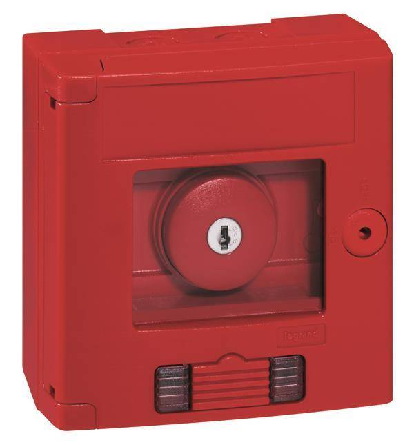 Ein roter manueller Feueralarmmelder mit klarer Scheibe, mit einem weißen runden Schlüsselloch und einer Klappenvorrichtung zur Aktivierung.