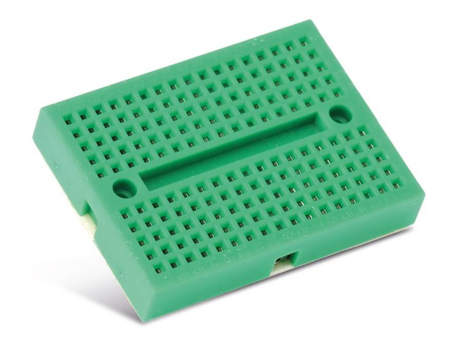 Ein kleines grünes Steckbrett ohne Löten mit mehreren Löchern, das zum Prototyping von elektronischen Schaltungen verwendet wird.