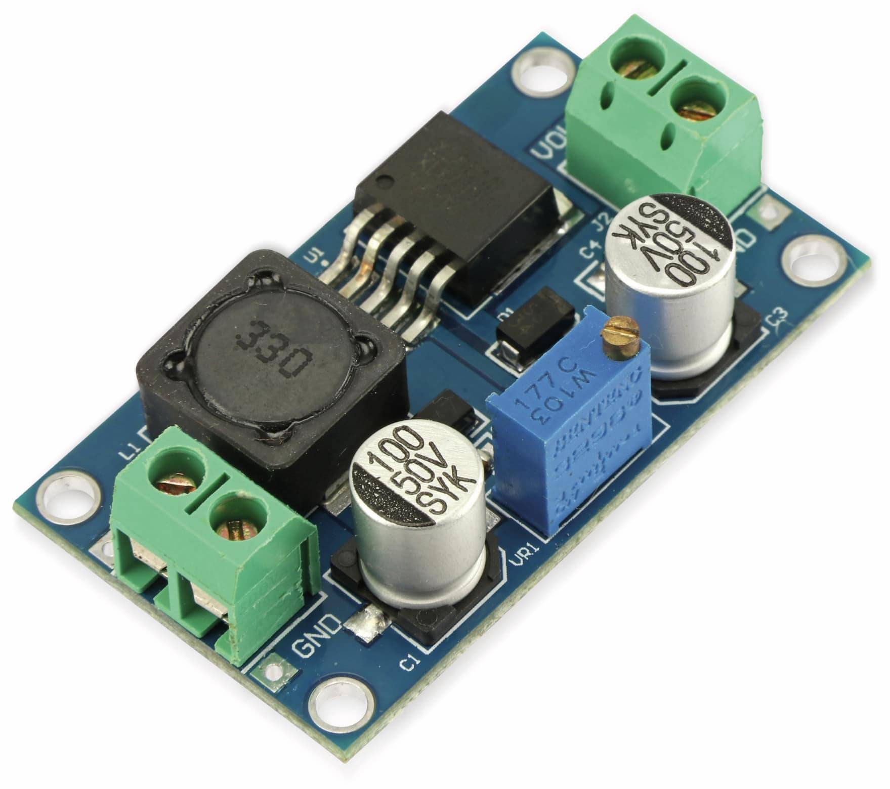 Eine kleine elektronische Leiterplatte mit verschiedenen Komponenten: grüne Anschlussklemmen, Kondensatoren mit der Bezeichnung „100