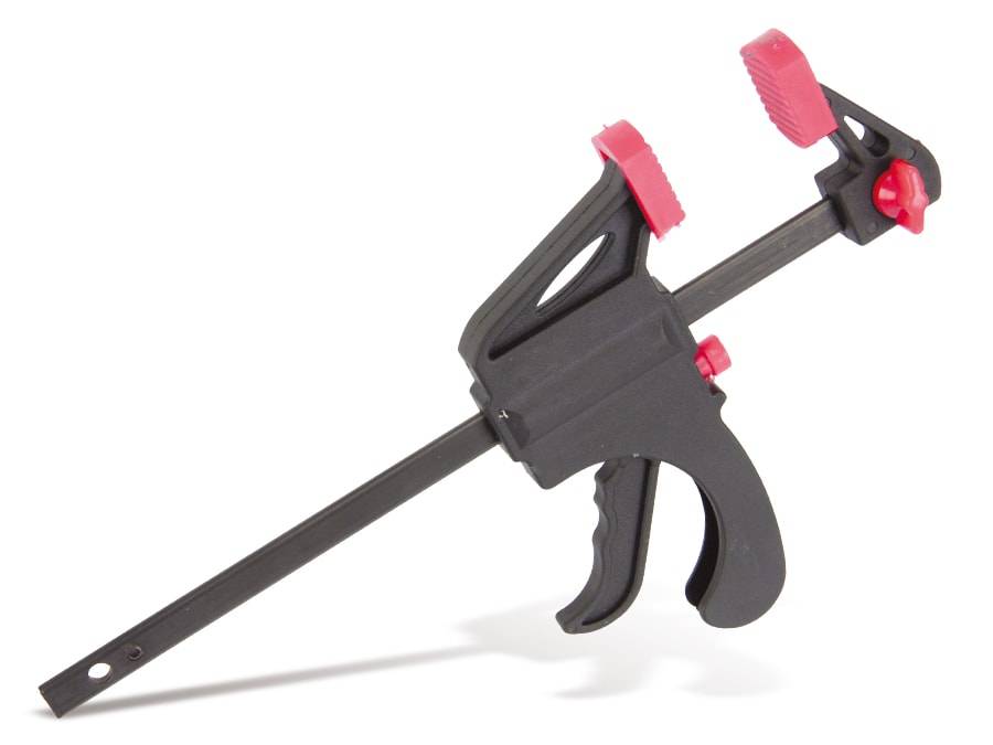 Eine schwarze und rote Schraubzwinge mit Griff und Schiebemechanismus, die zum sicheren Halten von Objekten bei Holzbearbeitungs- oder Konstruktionsaufgaben verwendet wird.