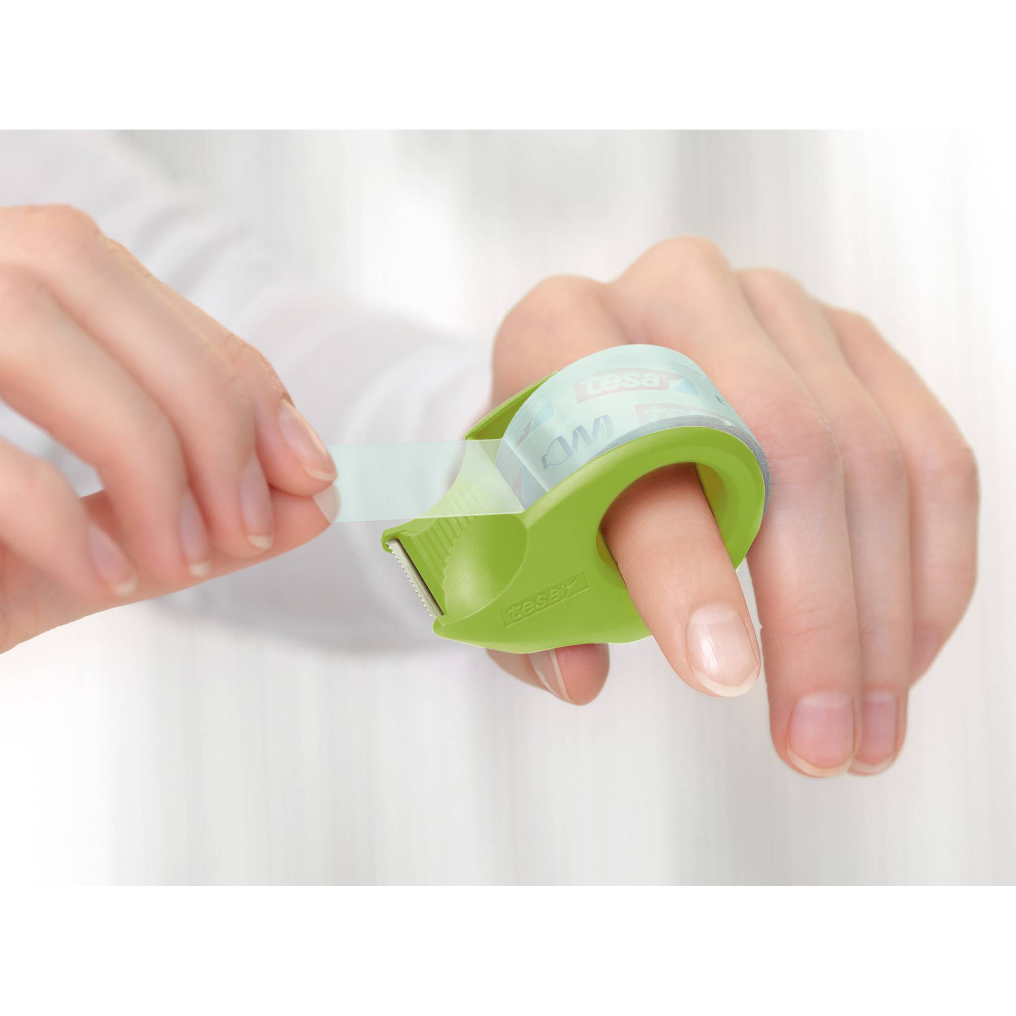 Hände verwenden ein grünes Klebeband-Abroller, um durchsichtiges Klebeband um einen Finger zu wickeln, was eine schützende Fingerverbandstechnik demonstriert.