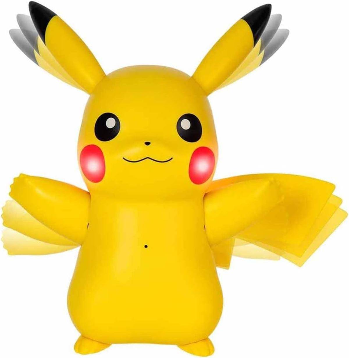 Ein großes aufblasbares Pikachu-Spielzeug mit ausgebreiteten Armen, leuchtend gelber Farbe, roten Wangen und schwarzspitzigen Ohren, das auf einer ebenen Fläche steht.
