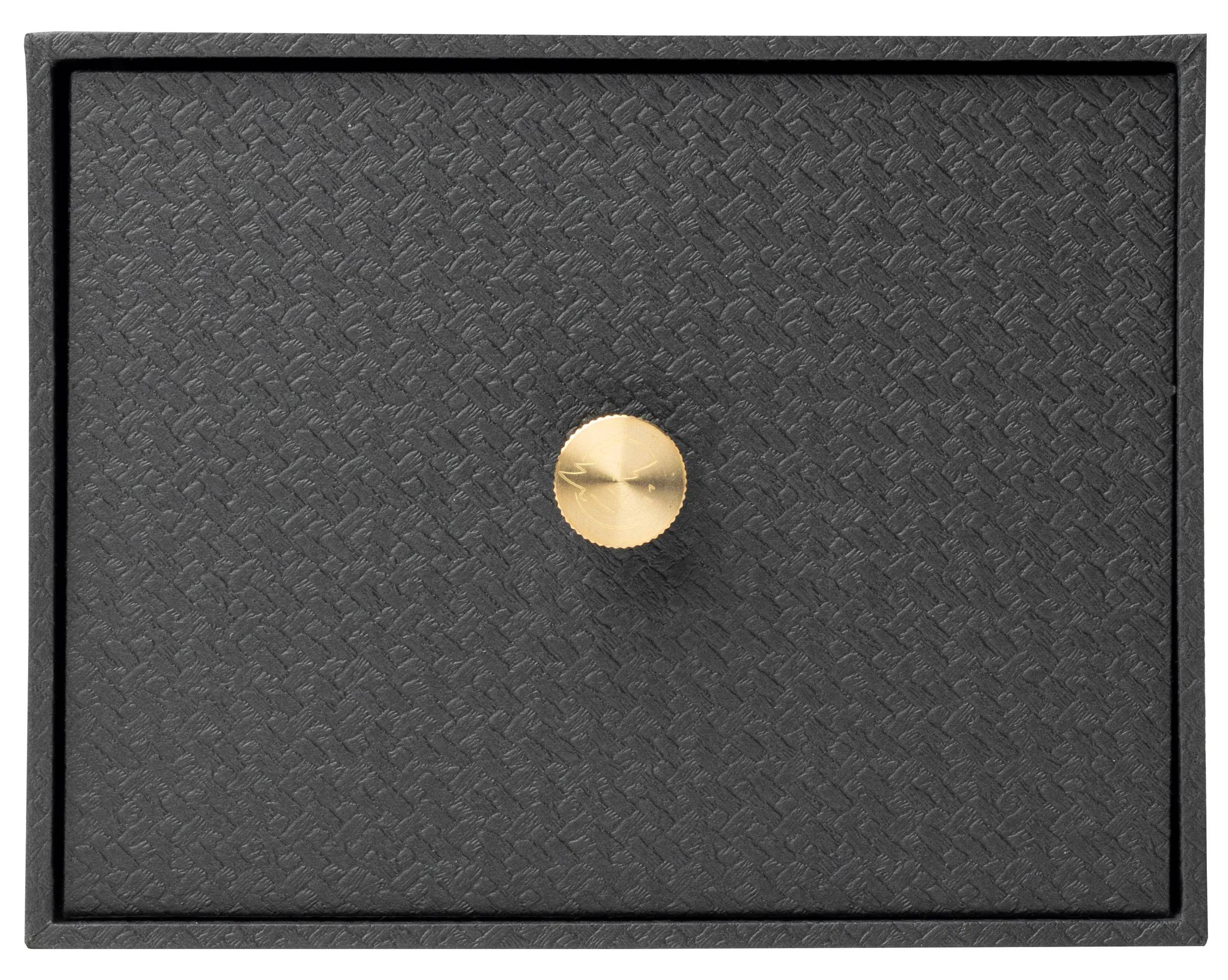 Eine schwarze strukturierte Schublade mit einem runden goldenen Griff in der Mitte.