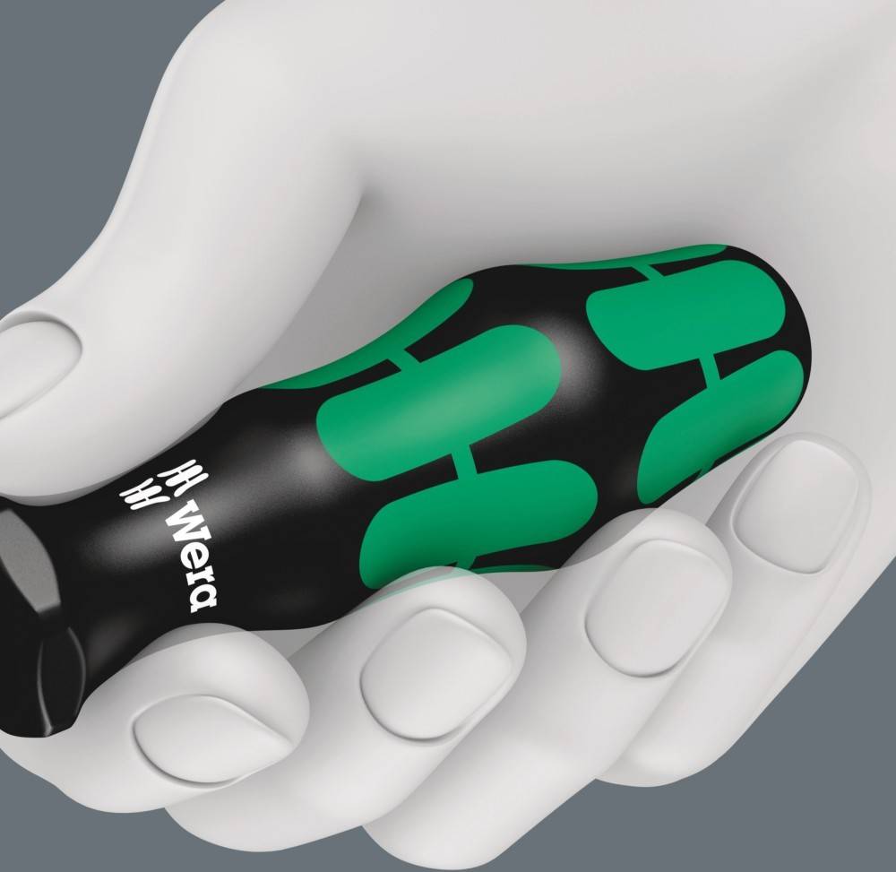 Eine Hand hält einen grün-schwarzen Schraubendreher, auf dessen Griff der Markenname 'Wera' deutlich zu sehen ist. Der Schraubendreher ist ergonomisch gestaltet.