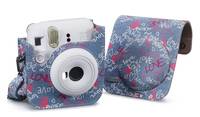 Blauer gemusterter Sofortbildkamera-Koffer mit einer vorderen Klappe und Riemen, shown holding a white instant camera.