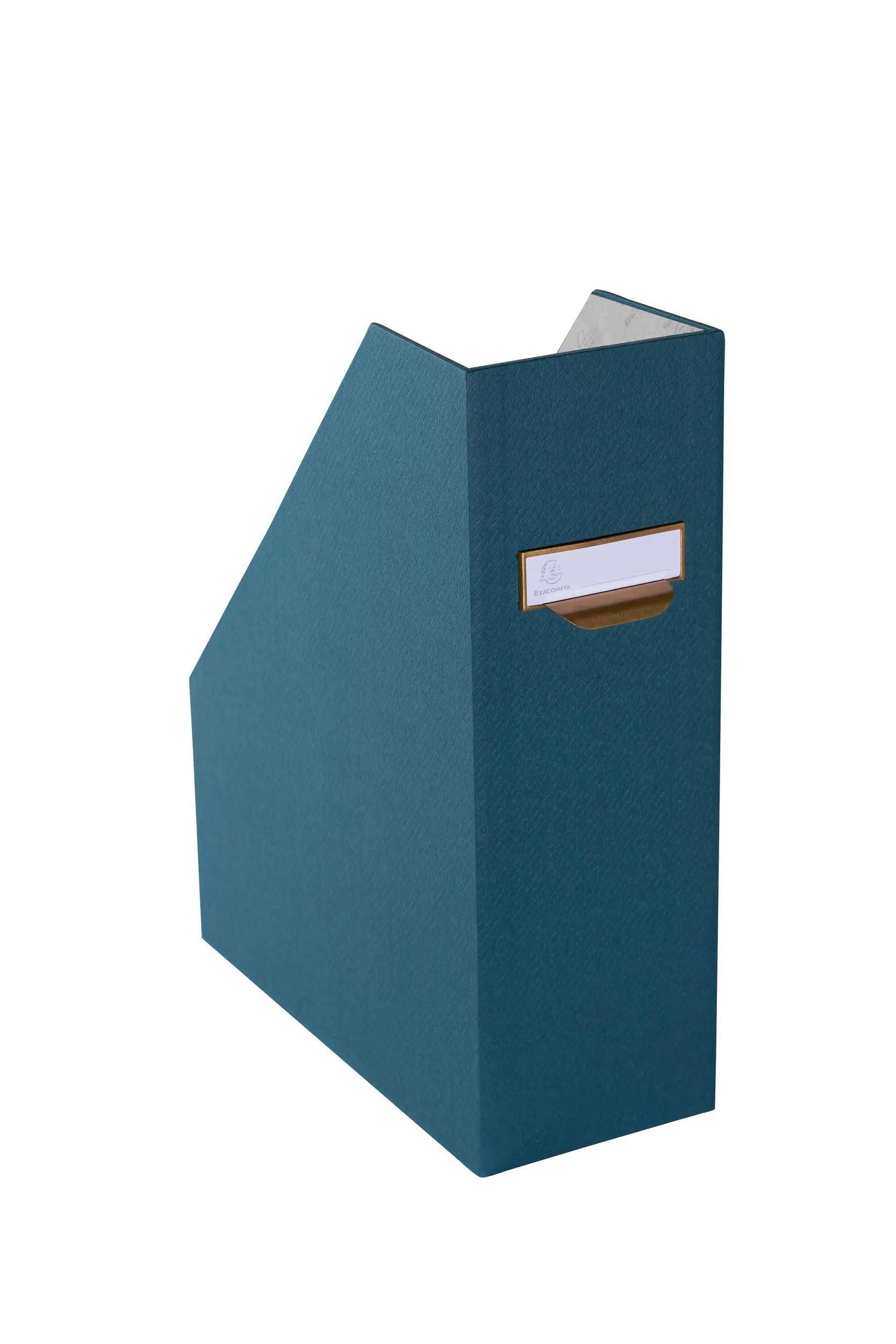 Ein blauer Kartonmagazinhalter mit einem Etikettenfeld an der Seite, aufrecht auf weißem Hintergrund stehend.