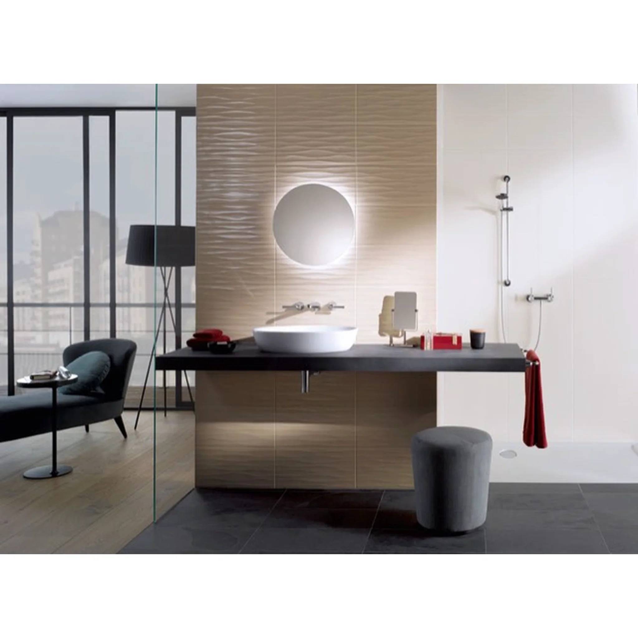 Modernes Badezimmer mit schwebendem schwarzem Waschtisch, rundem Spiegel, Aufsatzwaschbecken, Ducharmaturen, Hocker und Loungesessel neben einem großen Fenster.