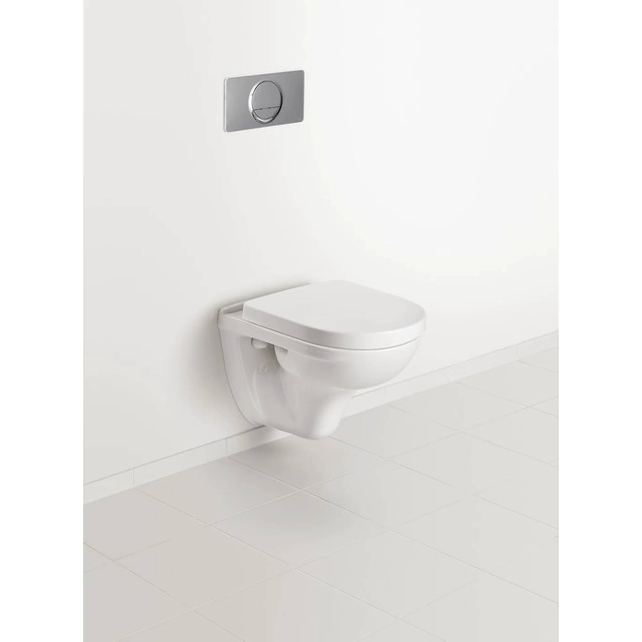 Wandmontierte weiße Toilette in einem minimalistischen weißen Badezimmer mit Spülplatte darüber.