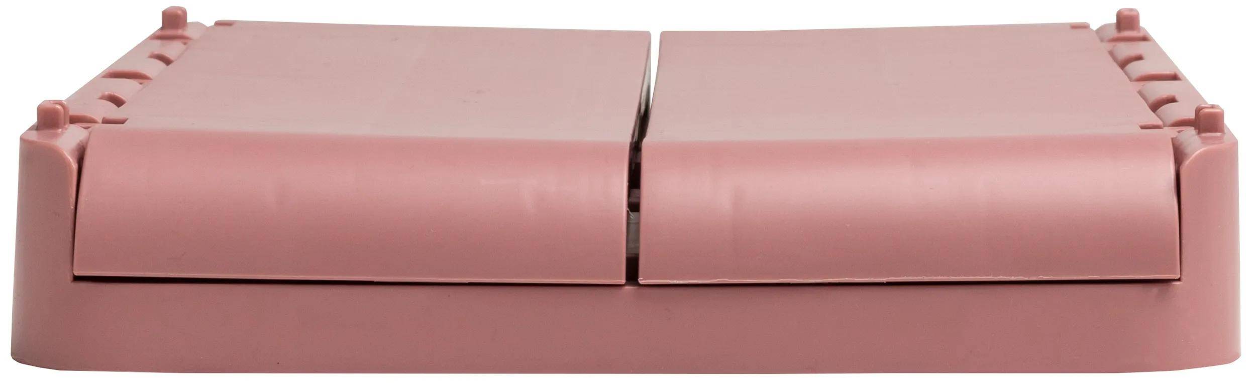 Eine Nahaufnahme eines rosa Tackers mit dem sichtbaren Metallbereich zum Laden von Heftklammern zwischen dem oberen und unteren Teil.