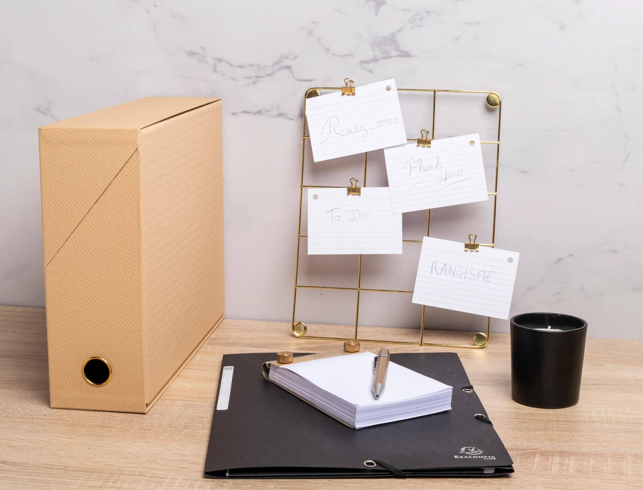 Eine strukturierte schwarze Kiste mit einem goldenen Knopf an der Vorderseite, aus einem Winkel betrachtet, was einen Lager- oder Organisationszweck nahelegt.