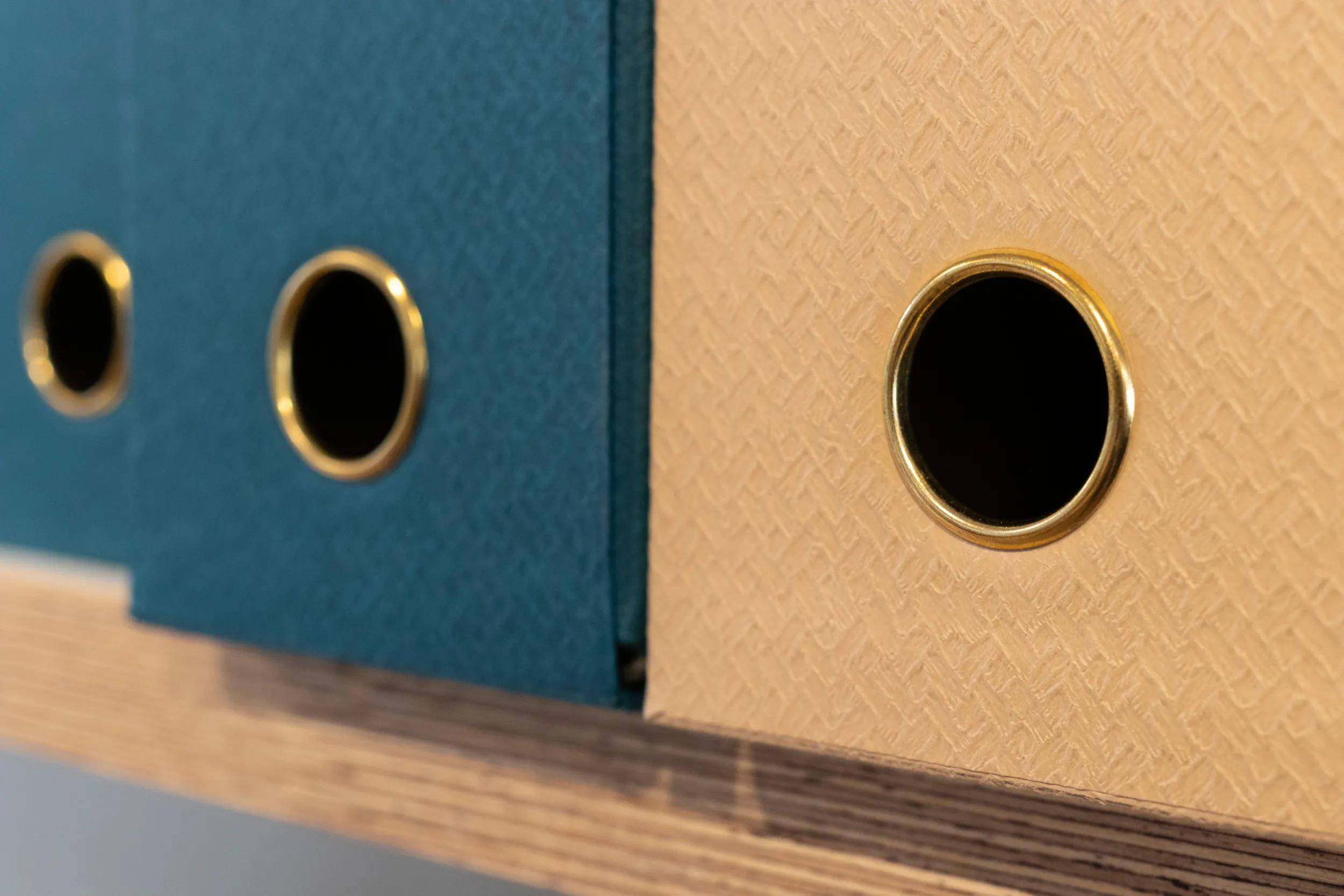 Eine orange, rechteckige Schachtel mit glatter Oberfläche und metallischen Akzenten, die an Verpackung oder einen Aufbewahrungskoffer erinnert, ohne Etiketten oder Text.