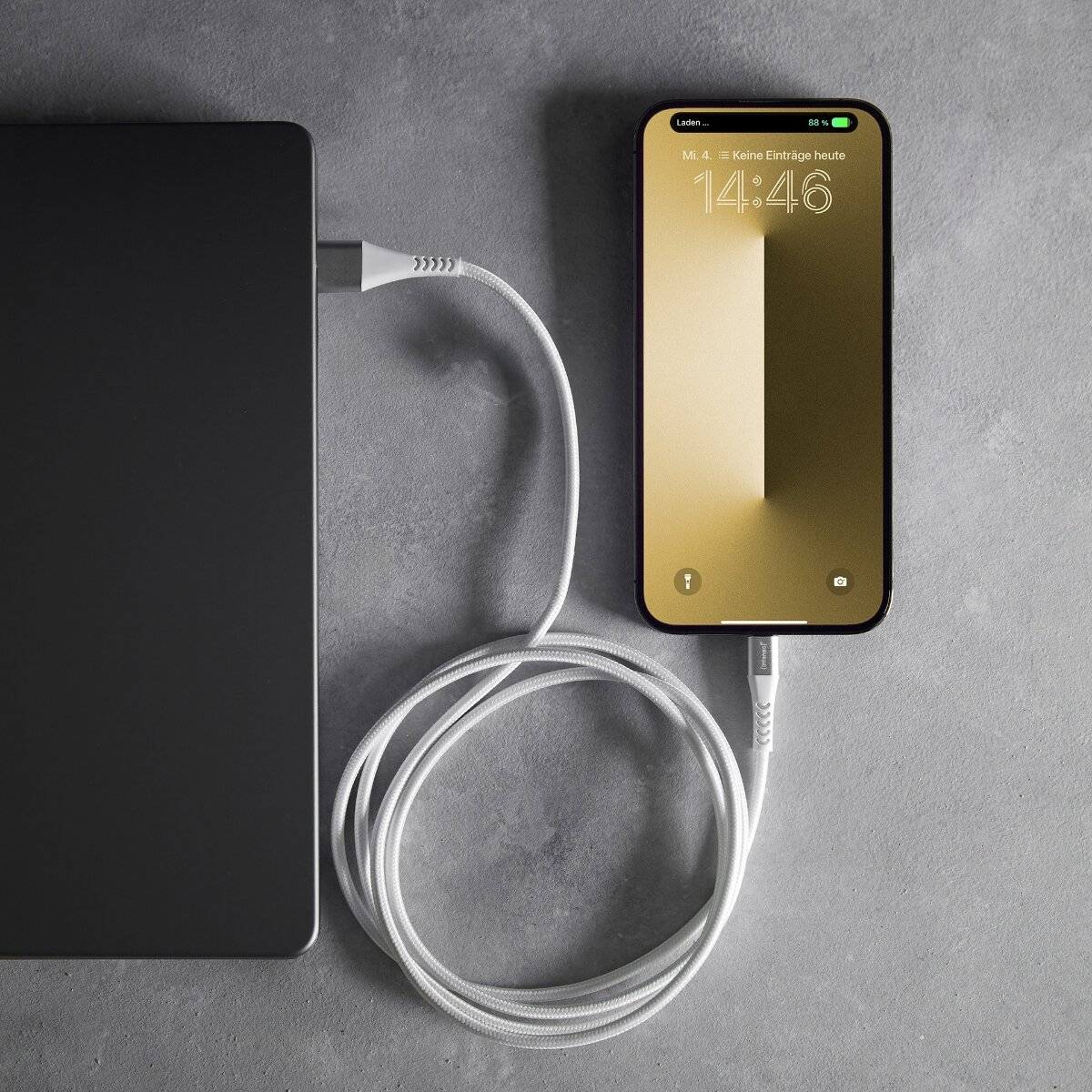 Ein Smartphone, das mit einer schlanken Powerbank über ein weißes Kabel verbunden ist, zeigt die Uhrzeit 14:46 und 64% Akkuladestand auf einem minimalistischen beigefarbenen Bildschirm an.