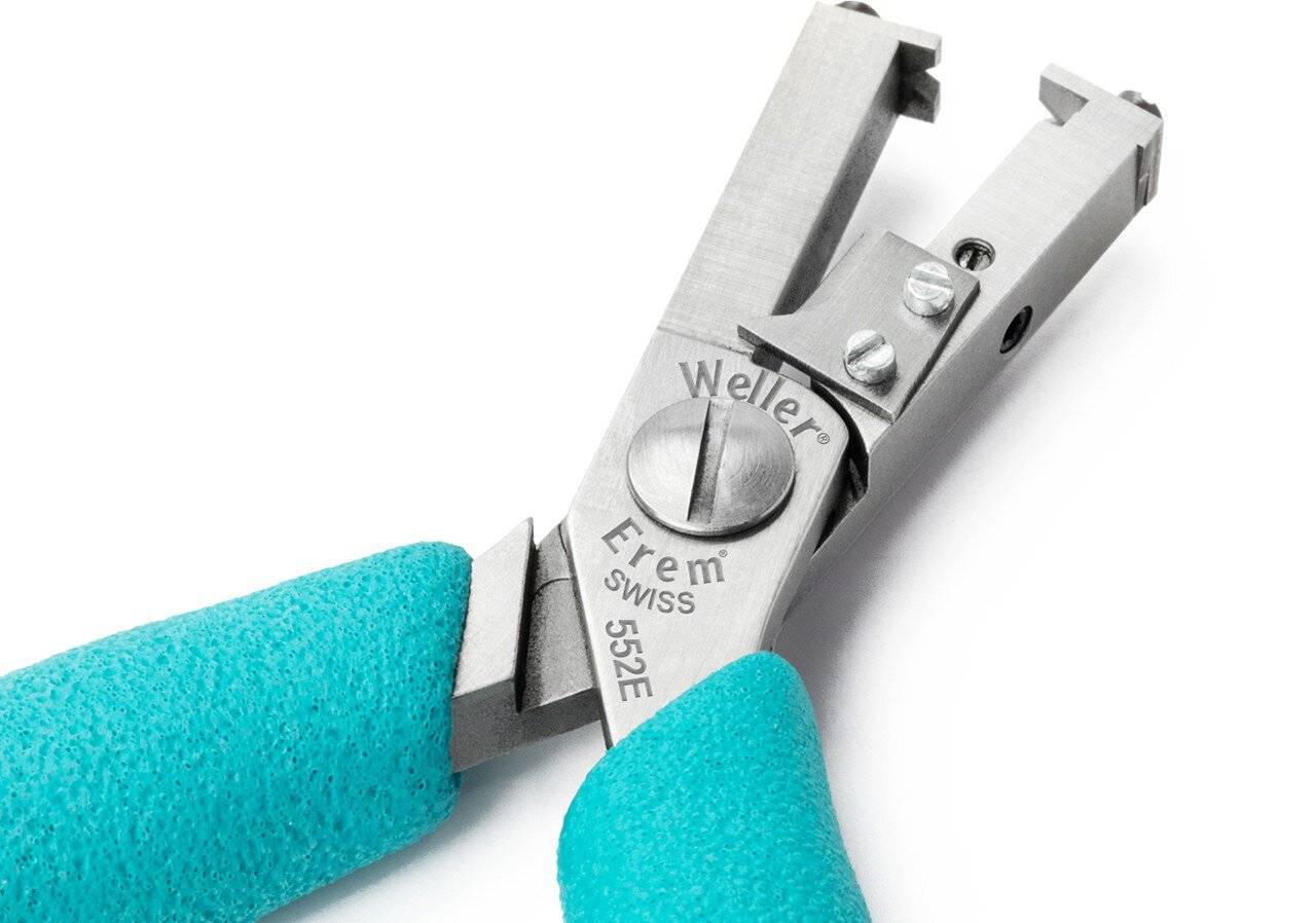 Nahaufnahme von blaugrünen Händen in Handschuhen, die ein Weller Erem Swiss 55E2 Präzisions-Schneidwerkzeug auf weißem Hintergrund halten.