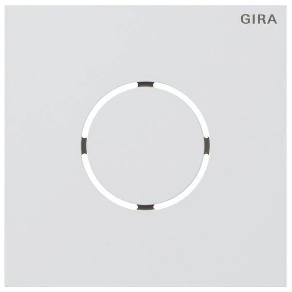 Ein weißer, quadratischer Berührungslichtschalter mit einem kreisförmigen Design in der Mitte, in der Ecke mit der Marke 'GIRA' versehen.
