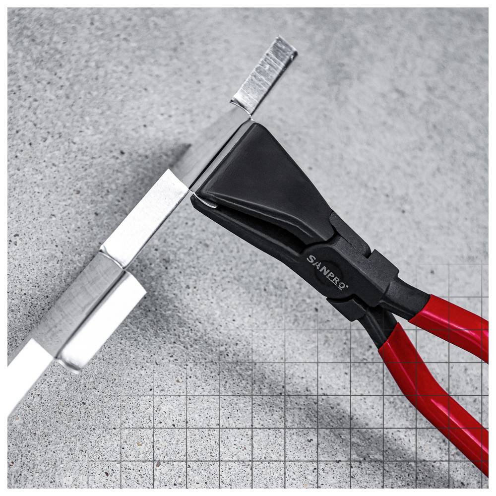 Metallwerkzeug mit roten Griffen hält einen flachen Metallstreifen vor einem grauen, gitternetzförmigen Hintergrund.