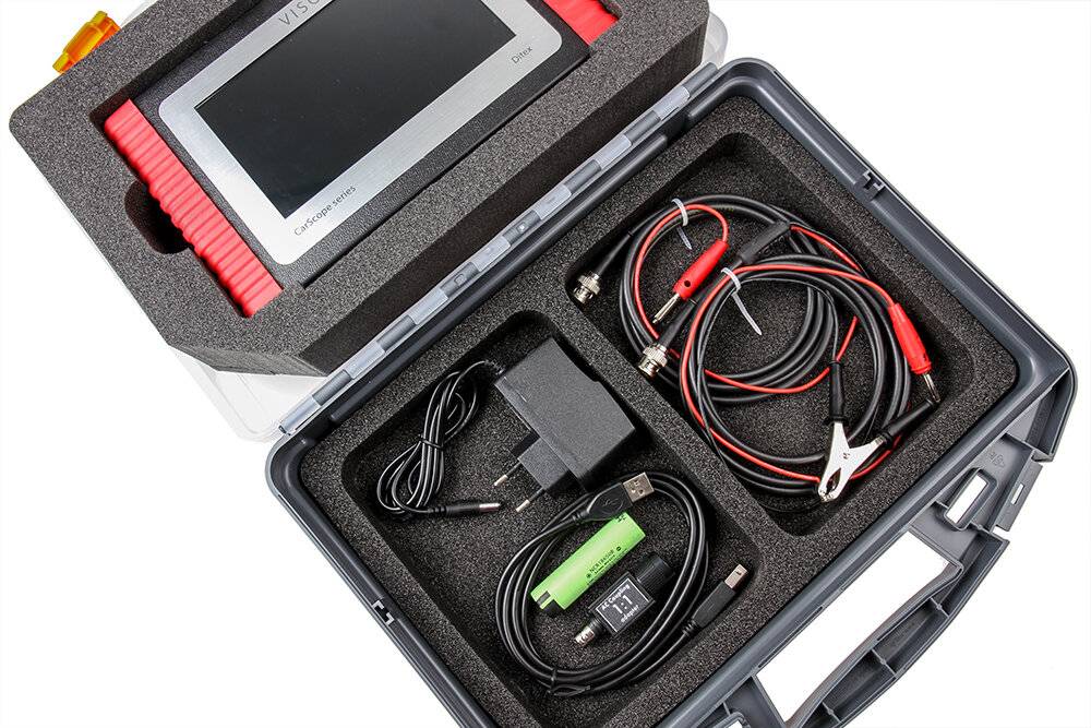 Diagnose-Toolkit mit einem Bildschirm oben; darunter sind Kabel, ein Ladegerät und Stecker ordentlich in einem Schaumstoffkoffer angeordnet.