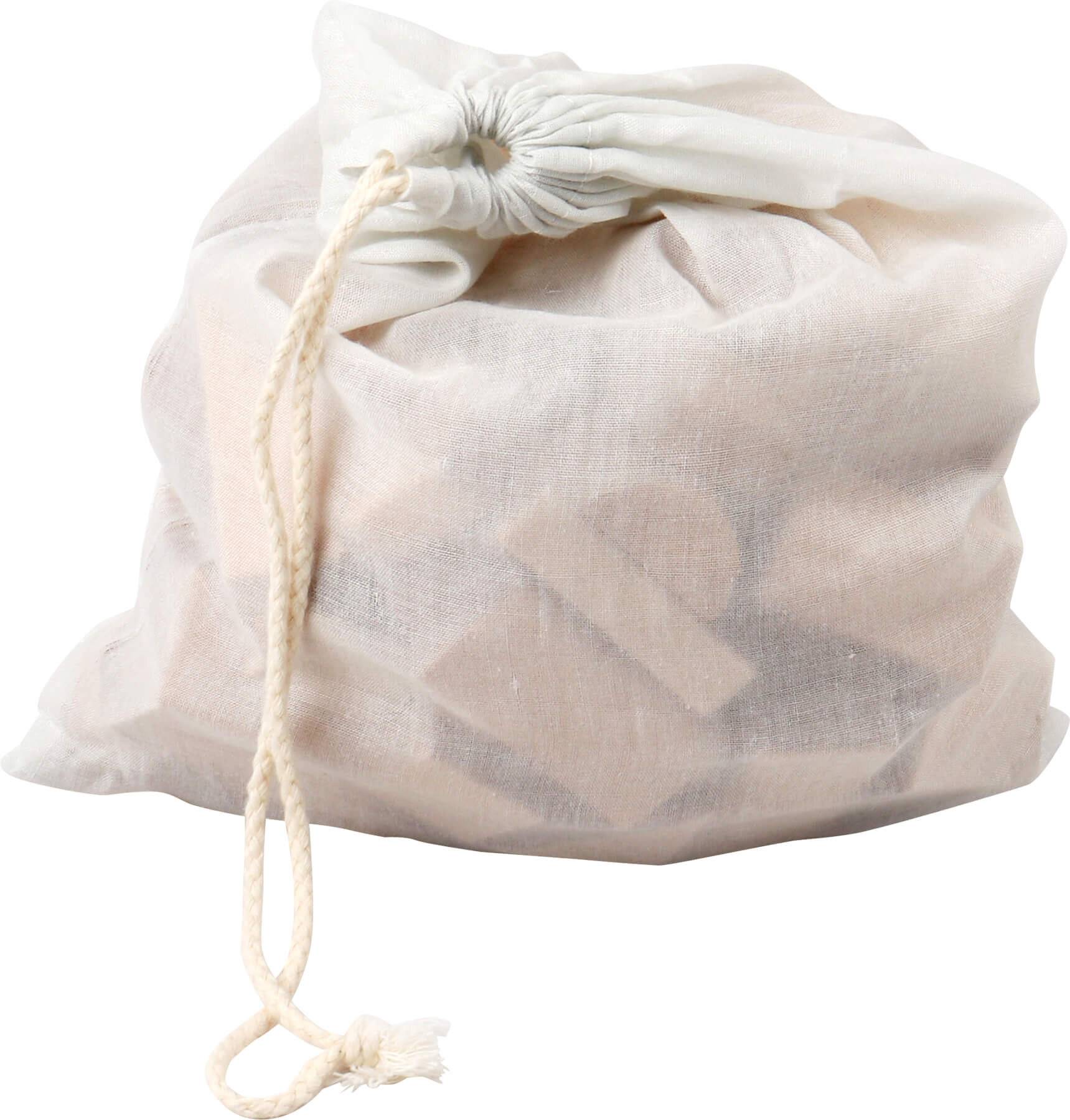 Weißer Wäschesack mit Kordelzug und Maschenstruktur, gefüllt mit Kleidung, oben zugebunden, vor einem einfachen Hintergrund.