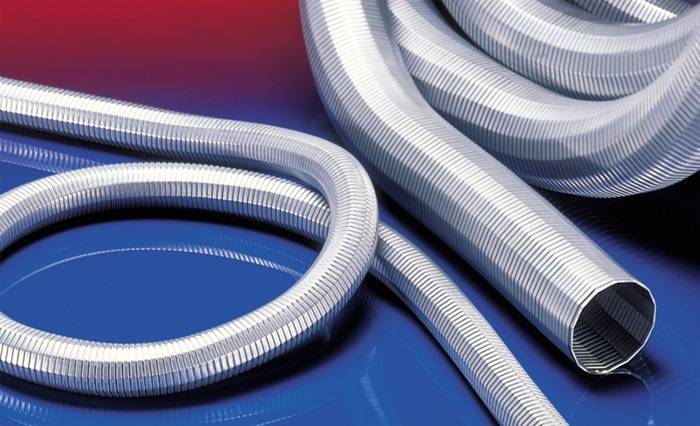 Gewickelter Silber-Metallschlauch, Nahaufnahme, auf einem Hintergrund mit Rot- und Blauverläufen. Der Schlauch reflektiert das Licht und zeigt seine geriffelte Textur.