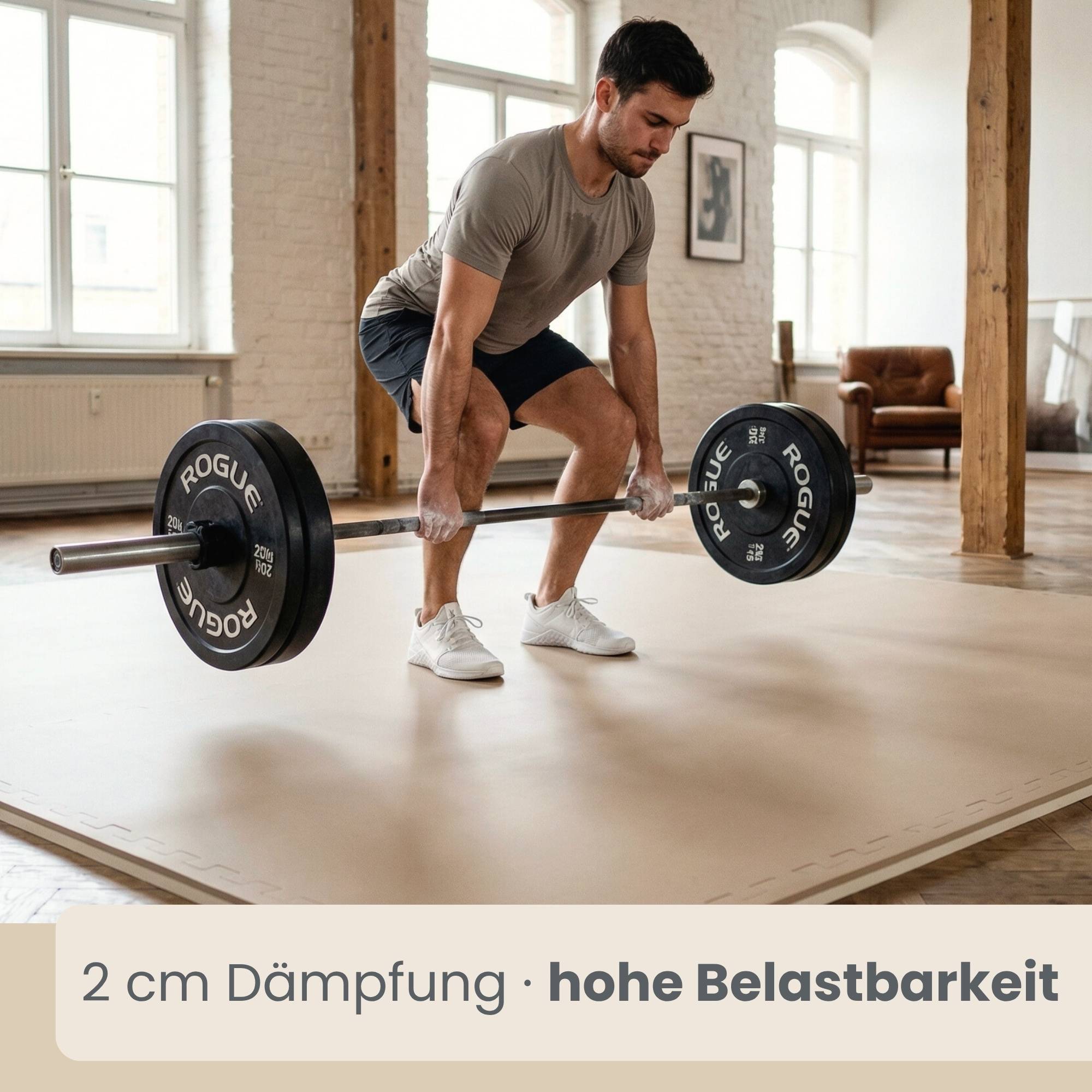 Ein Mann hebt eine beladene Langhantel auf einem gepolsterten Gymnastikasboden an; die Bannertexte lauten „2 cm Dämpfung • hohe Belastbarkeit