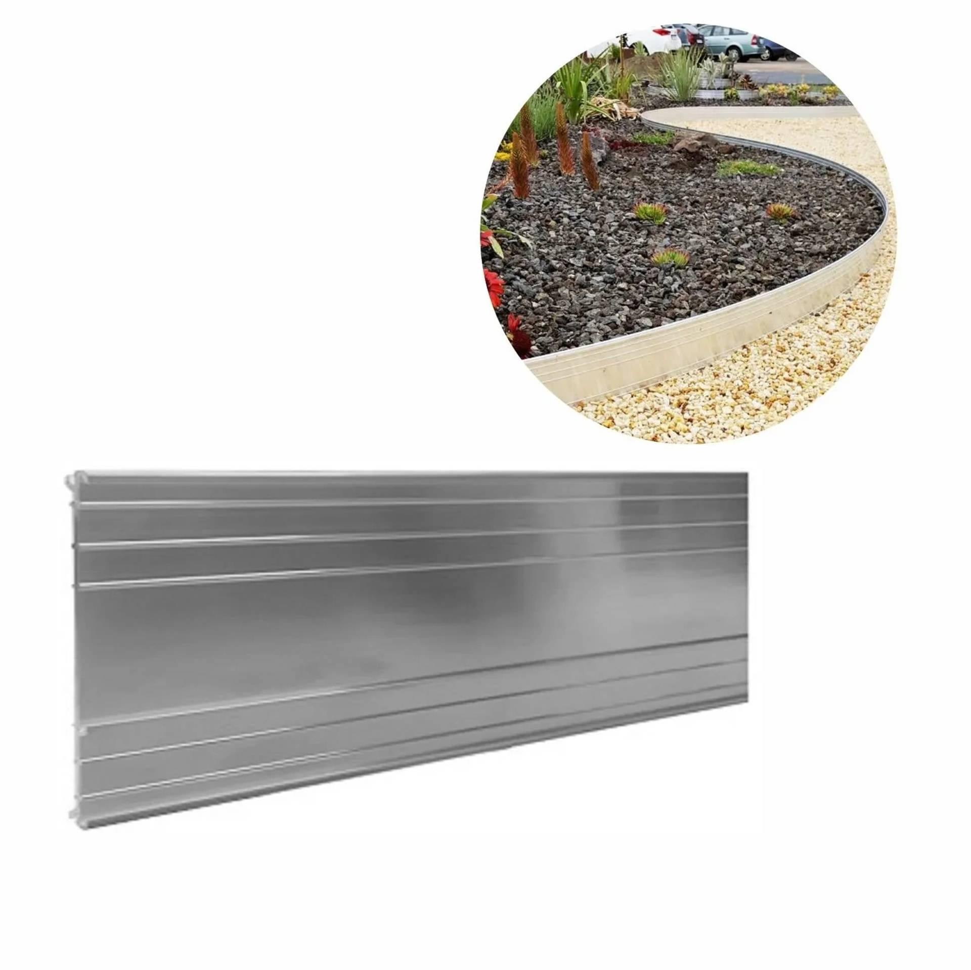 Silbernes Metallgarteneinfassungband, das entlang einer geschwungenen Gartengrenze installiert ist, um Kies und Pflanzbeete voneinander zu trennen.