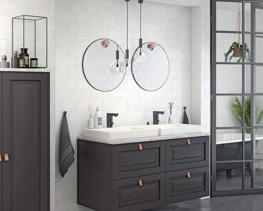 Modernes Badezimmer mit dunklem Doppelwaschbecken, zwei runden Spiegeln, Pendelleuchten und glerner Duschtür neben einem mit Pflanzen gefüllten Duschbereich.