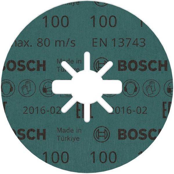 Ein grüner Bosch Schleifdisc mit Text einschließlich 'max. 80 m/s', 'EN 13743' und 'Made in Türkiye'. Zentrales Loch mit radialen Schlitzen.