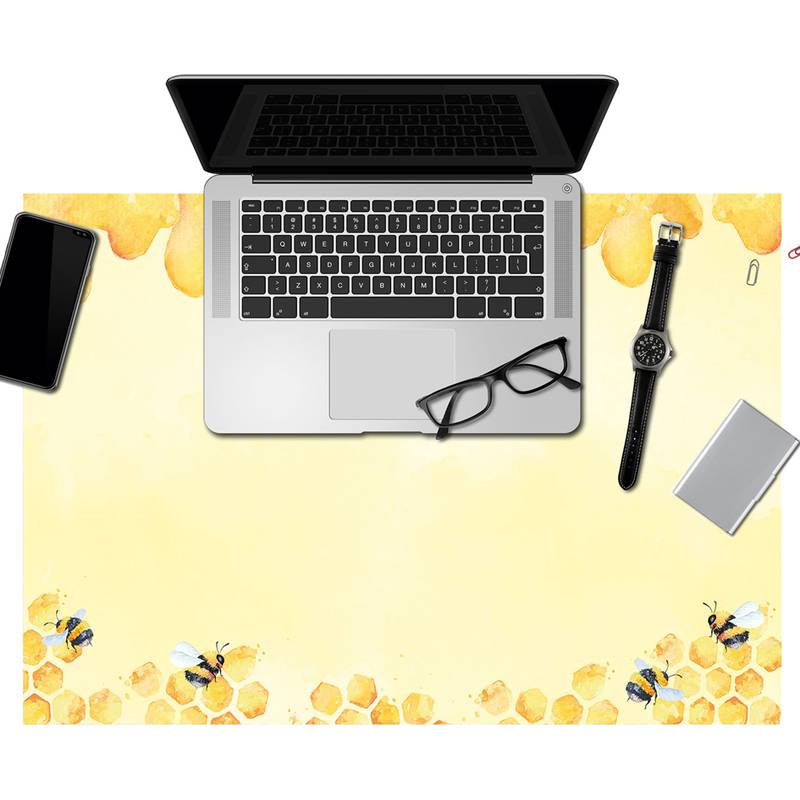 Ein Laptop steht offen auf einem gelben Schreibtisch mit Wabenmuster und Bienenillustrationen. In der Nähe befinden sich ein Smartphone, eine Brille, eine Uhr und ein Notizbuch.