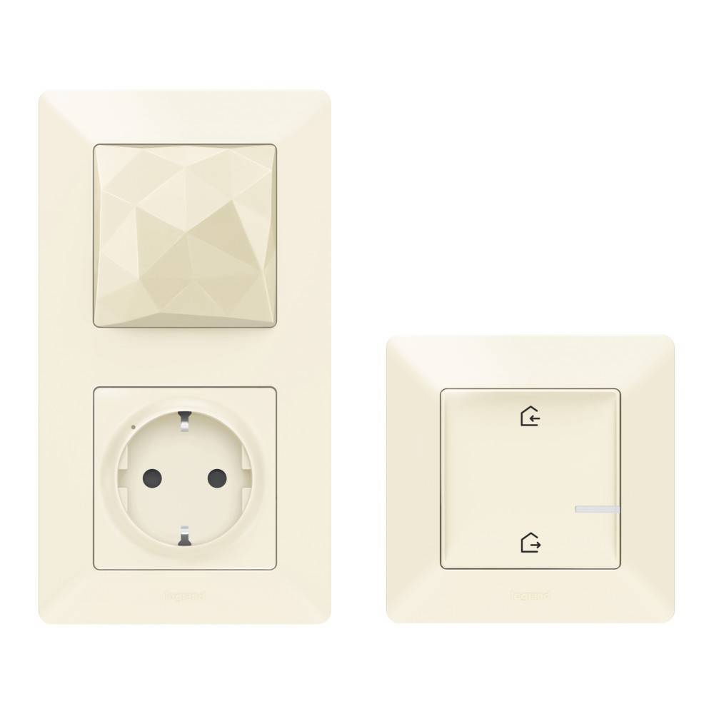 Ein cremefarbener Lichtschalter und eine Steckdose mit geometrisch gemusterter Oberfläche neben einem einzelnen Schalter mit Haushalts-Symbolen.