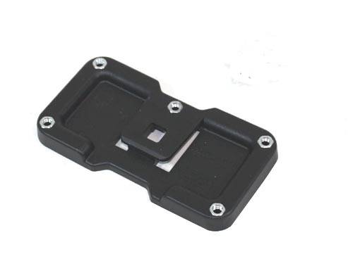 Eine Nahaufnahme einer schwarzen Kunststoffkomponente mit sechs Metallschrauben, möglicherweise eine Halterung oder Teil eines elektronischen Geräts.