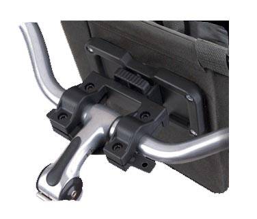 Ein Nahaufnahmebild eines schwarzen, verschließbaren Lenkstangenclips zum Befestigen einer Tasche am Fahrrad. Der Clip erscheint auf den Metallenlenkstangen gesichert.