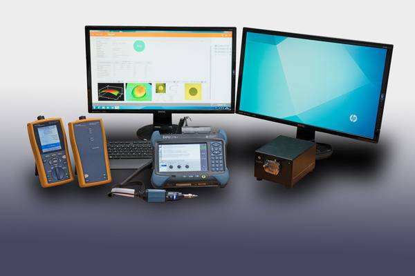 Das Bild zeigt verschiedene Test- und Messinstrumente, einschließlich zweier Monitore mit Softwareanzeigen, eines tragbaren Geräts und weiterer elektronischer Instrumente.
