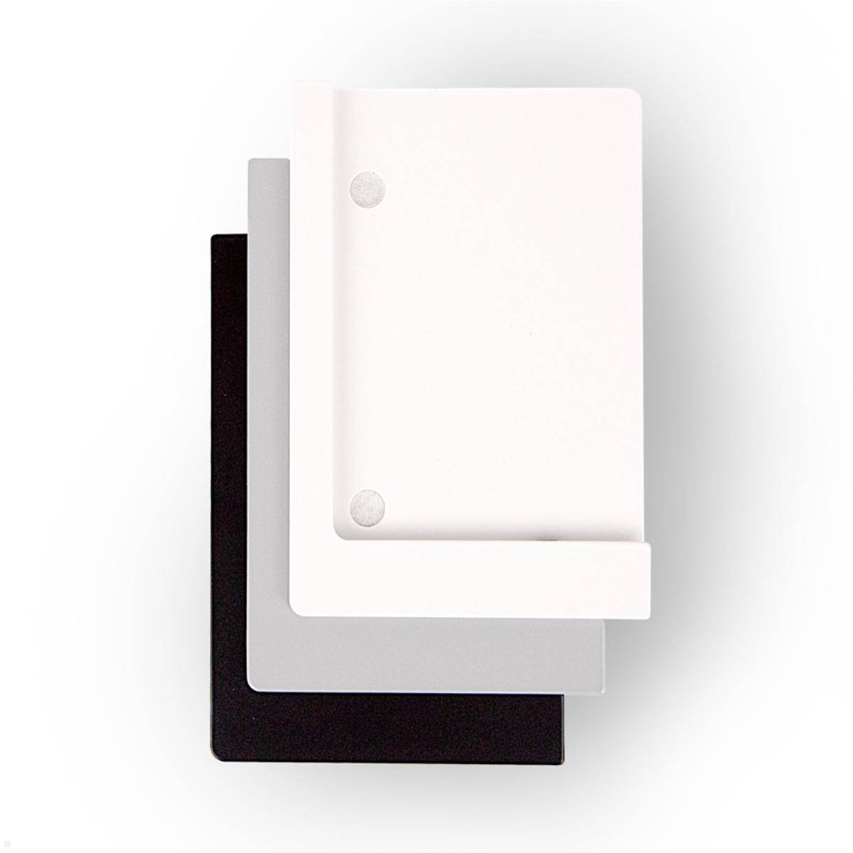 Drei gestapelte Notizbücher in Weiß, Grau und Schwarz, wobei das weiße Notizbuch oben liegt und zwei sichtbare Bindungslöcher zeigt.