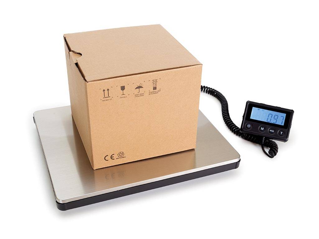 Pappkarton auf einer digitalen Versandwaage mit angebrachtem Display, das 0,97 anzeigt, wird zum Wiegen eines Pakets verwendet.