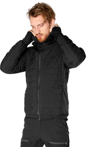 Eine Person in einer schwarzen Daunenjacke mit hochgezogener Kapuze, die ihr Gesicht mit den Händen verdeckt.