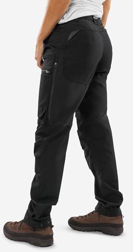 Eine Person trägt schwarze Cargohosen und steht mit einer Hand lässig in der Tasche, wobei der Schnitt und Stil der Hose betont werden.