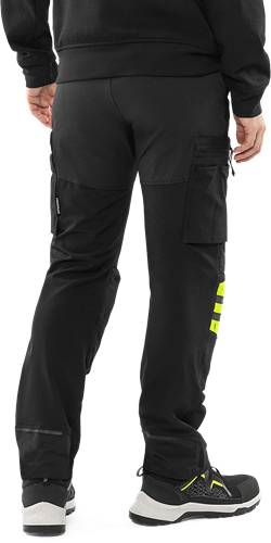 Schwarze Hose mit einer seitlichen Taschendetail und gelben Reflektorstreifen am rechten Bein. Eine Hand ist oben rechts sichtbar.