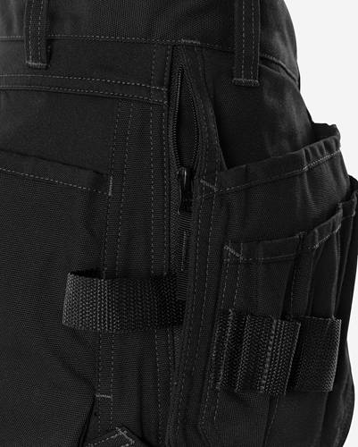 Nahaufnahme einer schwarzen taktischen Hose mit mehreren Taschen und einem Reißverschluss, entwickelt für Funktionalität und Stauraum.