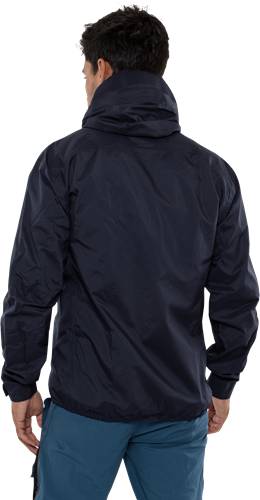 Eine Person, die eine dunkle Jacke trägt und mit dem Rücken zur Kamera steht, mit heruntergeschlagenem Kapuzenrand, vor einem schwarzen Hintergrund.