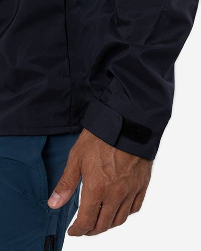 Eine Person trägt eine dunkle Jacke, wobei die linke Hand teilweise sichtbar ist und einen schwarzen verstellbaren Riemen am Ärmel der Jacke zeigt.