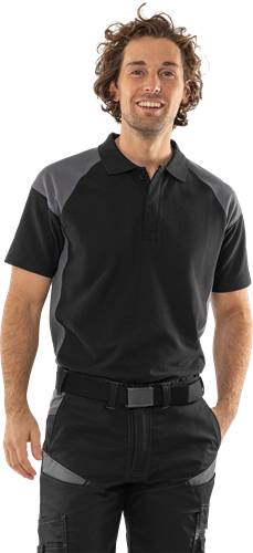 Eine Person trägt ein schwarzes und graues Poloshirt, mit Fokus auf den Oberkörper, vor einem neutralen Hintergrund.