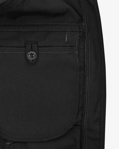 Schwarze Stofftasche mit Knopfverschluss an einem Kleidungsstück.