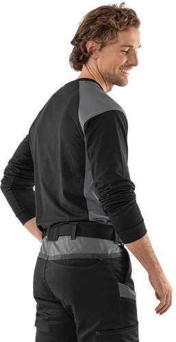 Eine Person, die ein langärmliges schwarz-graues Shirt trägt, von hinten gesehen, mit leicht gebeugten Armen und Händen in Hüfthöhe.