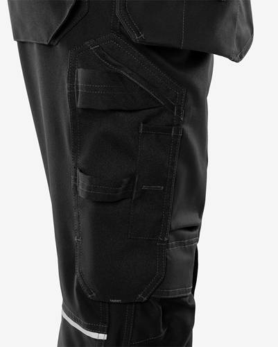 Eine Nahaufnahme von schwarzen Arbeitshosen mit mehreren Taschen und verstärkten Nähten, die einen strapazierfähigen Stoff zeigt, der für Funktionalität und Robustheit konzipiert ist.
