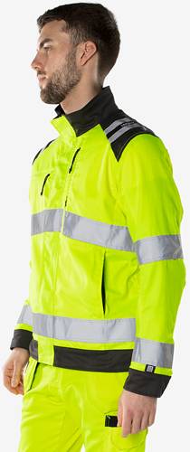 Eine Person, die eine neongelbe Sicherheitsweste mit reflektierenden Streifen trägt, mit Fokus auf den Oberkörper.