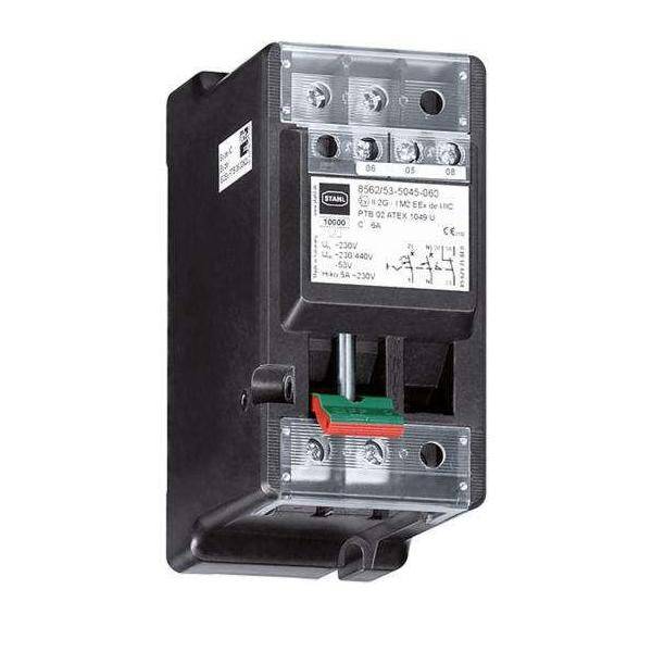 Ein schwarzer und grauer Industrie-Schalter mit gelbem Bedienknopf, an einer Wand montiert, wird verwendet, um die Stromversorgung oder Funktion von Geräten zu steuern.